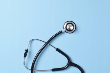 Açık mavi arka planda steteskop, üst manzara, yakın çekim. Metin için boşluk