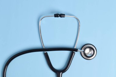 Açık mavi arkaplanda steteskop, üst görünümde, yakın plan