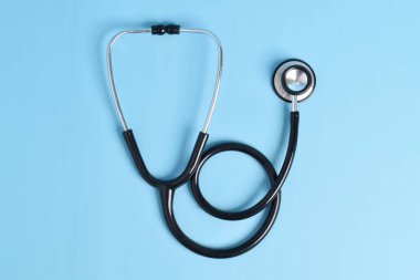 Açık mavi arka planda yeni steteskop, üst manzara. Tıbbi araç