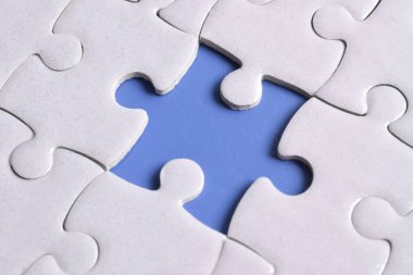 Mavi arkaplanda eksik parçalı beyaz bulmaca, yakın plan