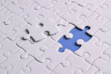 Kayıp yapboz parçaları ve mavi arka planda iş konsepti. Son görev tamamlanıyor