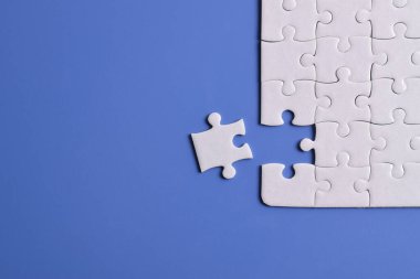 Mavi arka planda beyaz yapboz parçaları. Düz yatıyordu. Üst görünüm