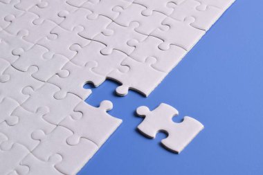 Mavi arka planda beyaz yapboz parçaları. Düz yatıyordu. Üst görünüm