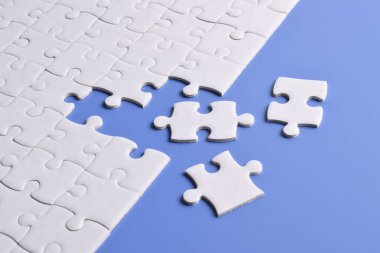 Mavi arka planı eksik olan beyaz bulmaca. Düz yatıyordu. Üst görünüm