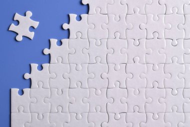 Mavi arka planda beyaz yapboz parçaları. Düz yatıyordu. Üst görünüm