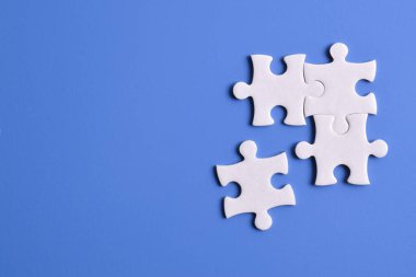 Mavi arka planda dört yapboz parçası. Takım çalışmasında doğru çözümleri bulma kavramı.
