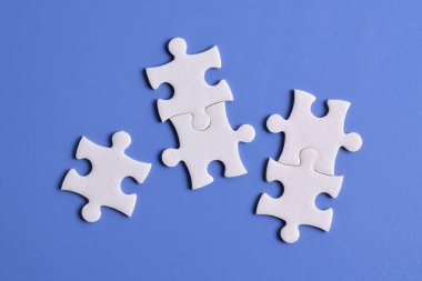 Mavi arkaplanda beyaz yapboz parçaları, üst görünüm