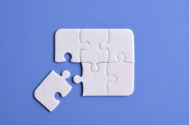 Mavi arka planda beyaz yapboz parçaları. Düz yatıyordu. Üst görünüm