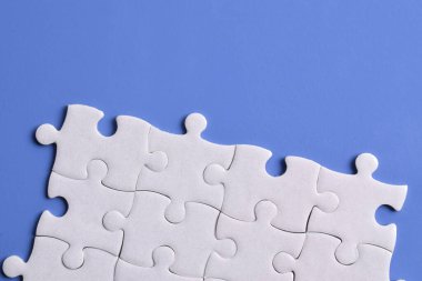 Mavi arka planda beyaz yapboz parçaları. Metin için boşluk kopyala, üst görünüm.