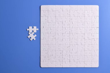 Mavi arka planda beyaz yapboz parçaları. Beyaz kare yapboz parçaları ızgarası. İş geçmişi. Metin için boşluk kopyala, üst görünüm.