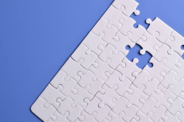 Mavi arka planda beyaz yapboz parçaları. Beyaz kare yapboz parçaları ızgarası. İş geçmişi. Metin için boşluk kopyala, üst görünüm.