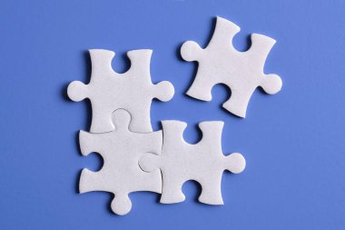 Mavi arka planda dört yapboz parçası. Takım çalışmasında doğru çözümleri bulma kavramı.