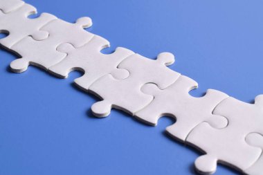 Beyaz bulmaca parçaları mavi arkaplanda bir çizgi oluşturuyor