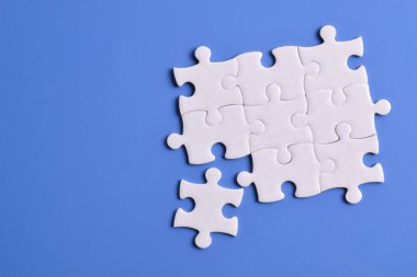 Mavi arka planda beyaz yapboz parçaları. Metin için boşluk kopyala, üst görünüm.