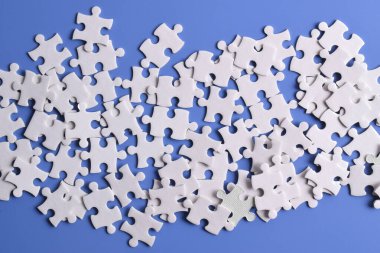 Arkaplan olarak beyaz yapboz parçaları yığını, üst görünüm