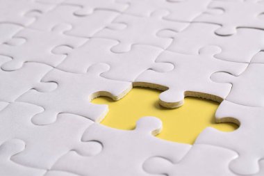 Sarı arkaplanda eksik parçalı beyaz bulmaca, yakın plan