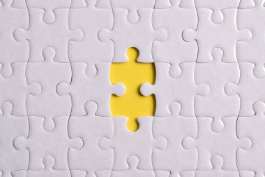 Sarı arkaplanda eksik parçalı beyaz bulmaca, yakın plan