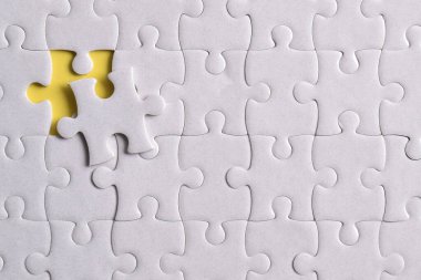 Kayıp yapboz parçaları ve sarı arka planda iş konsepti. Son görev tamamlanıyor