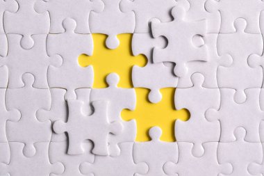 Sarı arka plandaki beyaz yapbozu kapat, başarılı iş, akıllı fikir ve takım çalışması kavramını planla ve yönet