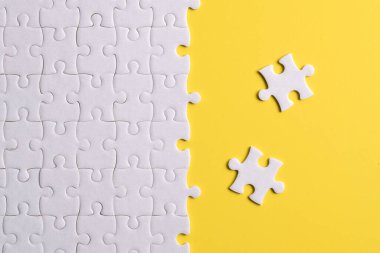 Mavi arka planda beyaz yapboz parçaları. Düz yatıyordu. Üst görünüm