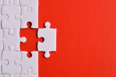 Kırmızı arka planda beyaz yapboz parçaları. Düz yatıyordu. Üst görünüm