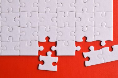 Kırmızı arka planda kayıp parçalı beyaz bulmaca. Düz yatıyordu. Üst görünüm