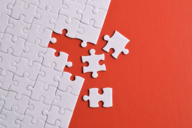 Kırmızı arka planda kayıp parçalı beyaz bulmaca. Düz yatıyordu. Üst görünüm