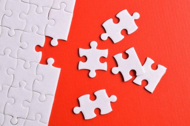 Kırmızı arka planda kayıp parçalı beyaz bulmaca. Düz yatıyordu. Üst görünüm