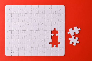 Kırmızı arka planda beyaz yapboz parçaları. Beyaz kare yapboz parçaları ızgarası. İş geçmişi. Metin için boşluk kopyala, üst görünüm.