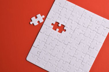 Kırmızı arka planda beyaz yapboz parçaları. Beyaz kare yapboz parçaları ızgarası. İş geçmişi. Metin için boşluk kopyala, üst görünüm.