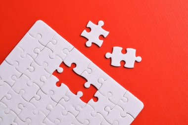 Kırmızı arka planda beyaz yapboz parçaları. Beyaz kare yapboz parçaları ızgarası. İş geçmişi. Üst görünüm