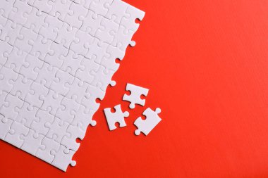 Kırmızı arka planda beyaz yapboz parçaları. Beyaz kare yapboz parçaları ızgarası. İş geçmişi. Metin için boşluk kopyala, üst görünüm.