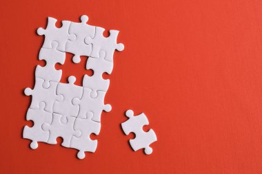 Kırmızı arka planda beyaz yapboz parçaları. Metin için boşluk kopyala, üst görünüm.