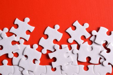 Kırmızı arka planda beyaz yapboz parçaları, üst manzara. Metin için boşluk