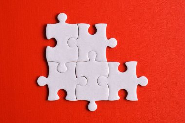 Kırmızı arka planda beş yapboz parçası. Takım çalışmasında doğru çözümleri bulma kavramı.