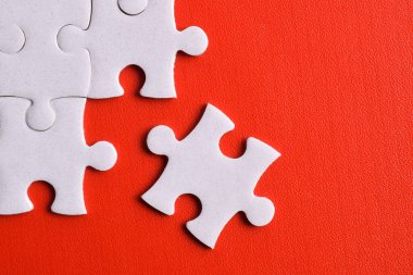 Kırmızı arkaplanda beyaz yapboz parçaları, üst görünüm