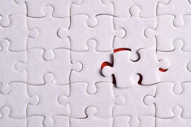 Kayıp yapboz parçaları ve kırmızı arka planda iş konsepti. Son görev tamamlanıyor