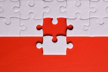 Kırmızı arka planda beyaz yapboz parçaları. Düz yatıyordu. Üst görünüm