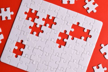 Kırmızı arka planda beyaz yapboz parçaları. Beyaz kare yapboz parçaları ızgarası. İş geçmişi. Üst görünüm