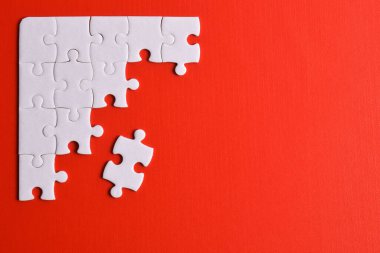 Kırmızı arka planda beyaz yapboz parçaları. Metin için boşluk kopyala, üst görünüm.