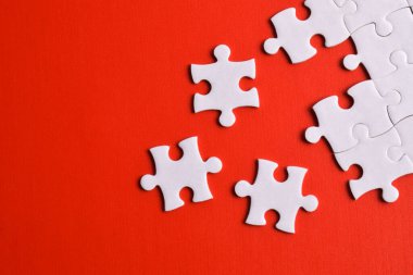 Kırmızı arka planda beyaz yapboz parçaları. Metin için boşluk kopyala, üst görünüm.