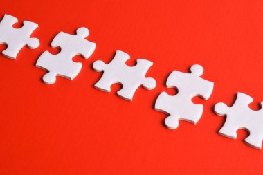 kırmızı arka plan üzerinde beyaz bulmaca parçaları.