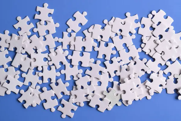 Arkaplan olarak beyaz yapboz parçaları yığını, üst görünüm