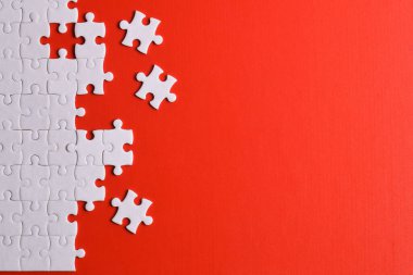 Kırmızı arka planda beyaz yapboz parçaları, üst manzara. Metin için boşluk