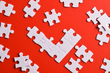 Kırmızı arkaplanda beyaz yapboz parçaları, üst görünüm