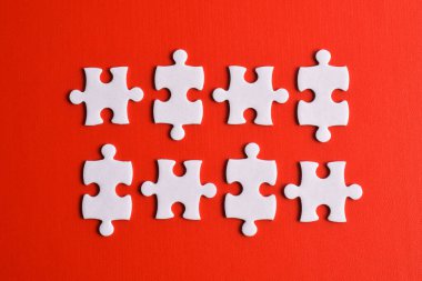 Kırmızı arkaplanda beyaz yapboz parçaları, üst görünüm