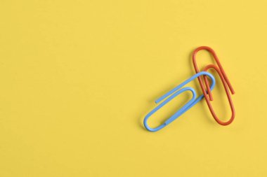 Sarı arkaplanda izole edilmiş iki ataç.