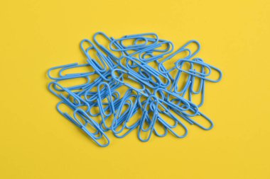 Sarı arkaplanda birçok mavi ataç izole edildi