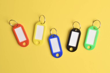 Sarı arka planda izole edilmiş renkli plastik anahtarlık. Üst manzara, düz uzanma