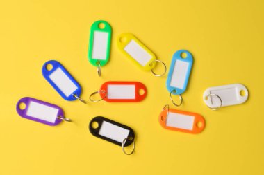 Sarı arka planda izole edilmiş renkli plastik anahtarlık. Üst manzara, düz uzanma